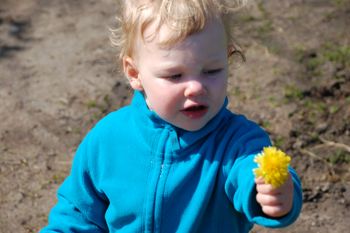 Lars geht freundlich auf alle auf dem Bauernhof zu und bietet Blümchen an